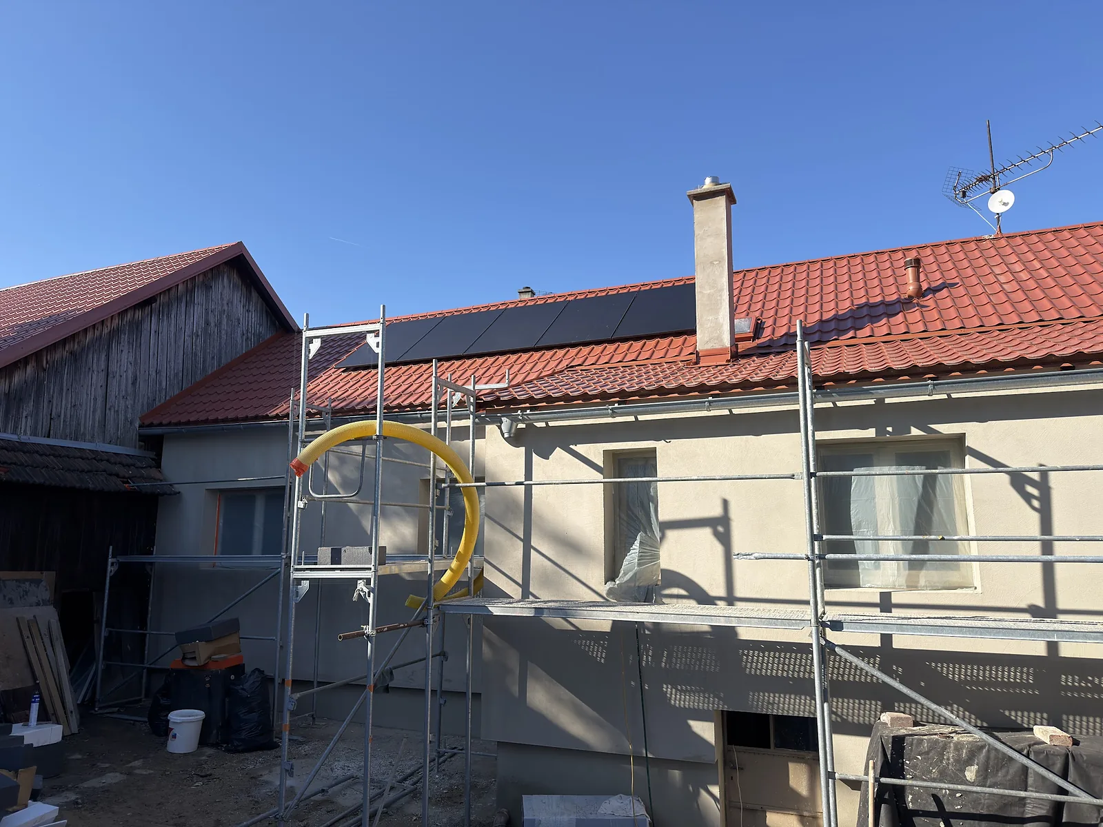 Dům v lešení, na střeše fotovoltaické panely