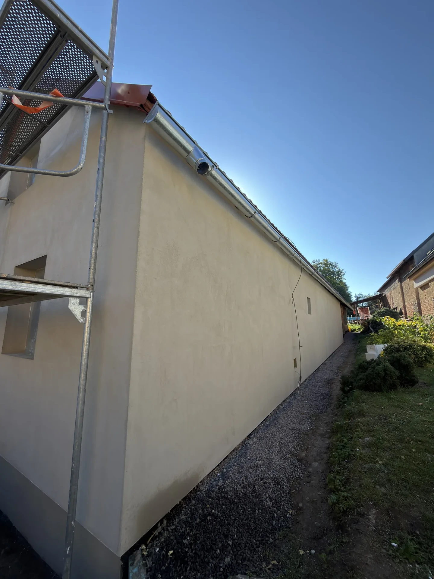 Nová fasáda rodinného domu během renovace, vlevo lešení